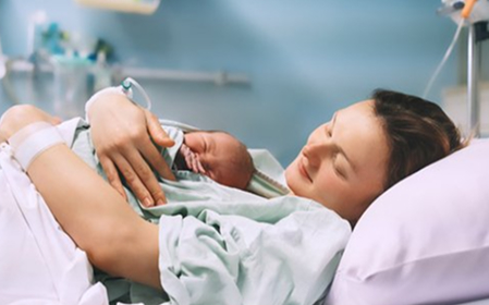 Mother with newborn on bed hospitl